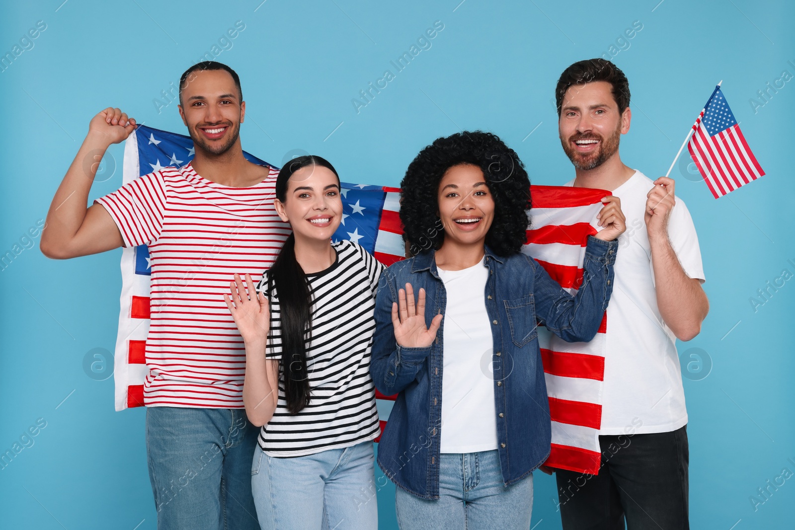 Photo of 4th of July - Independence Day of USA. Happy friends with American flags on light blue background