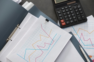 Folders with documents and calculator on office table, top view