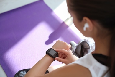 Photo of Woman checking fitness tracker in gym, closeup