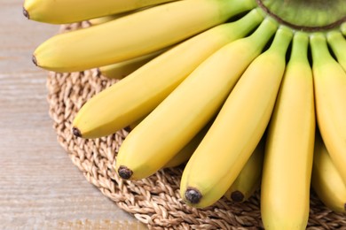 Photo of Bunch of ripe baby bananas on wooden table, closeup