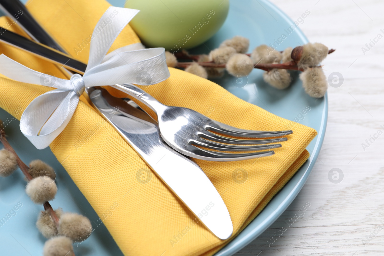 Photo of Festive Easter table setting with egg on white background, closeup