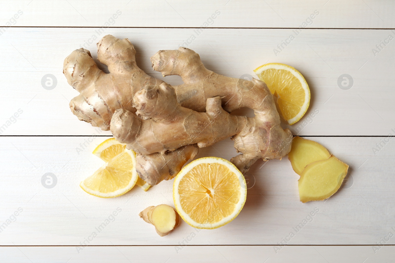 Photo of Fresh lemon and ginger on white wooden table, flat lay