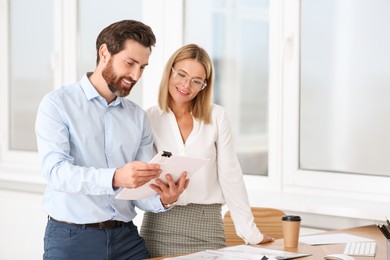 Photo of Happy businesspeople working with documents in office