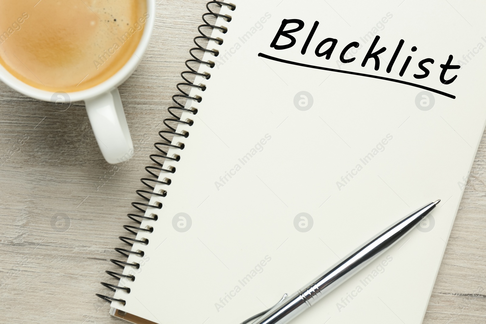 Image of Word Blacklist written in notepad and coffee on wooden background, flat lay