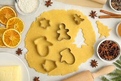 Photo of Flat lay composition with dough and cookie cutters on light table. Christmas biscuits