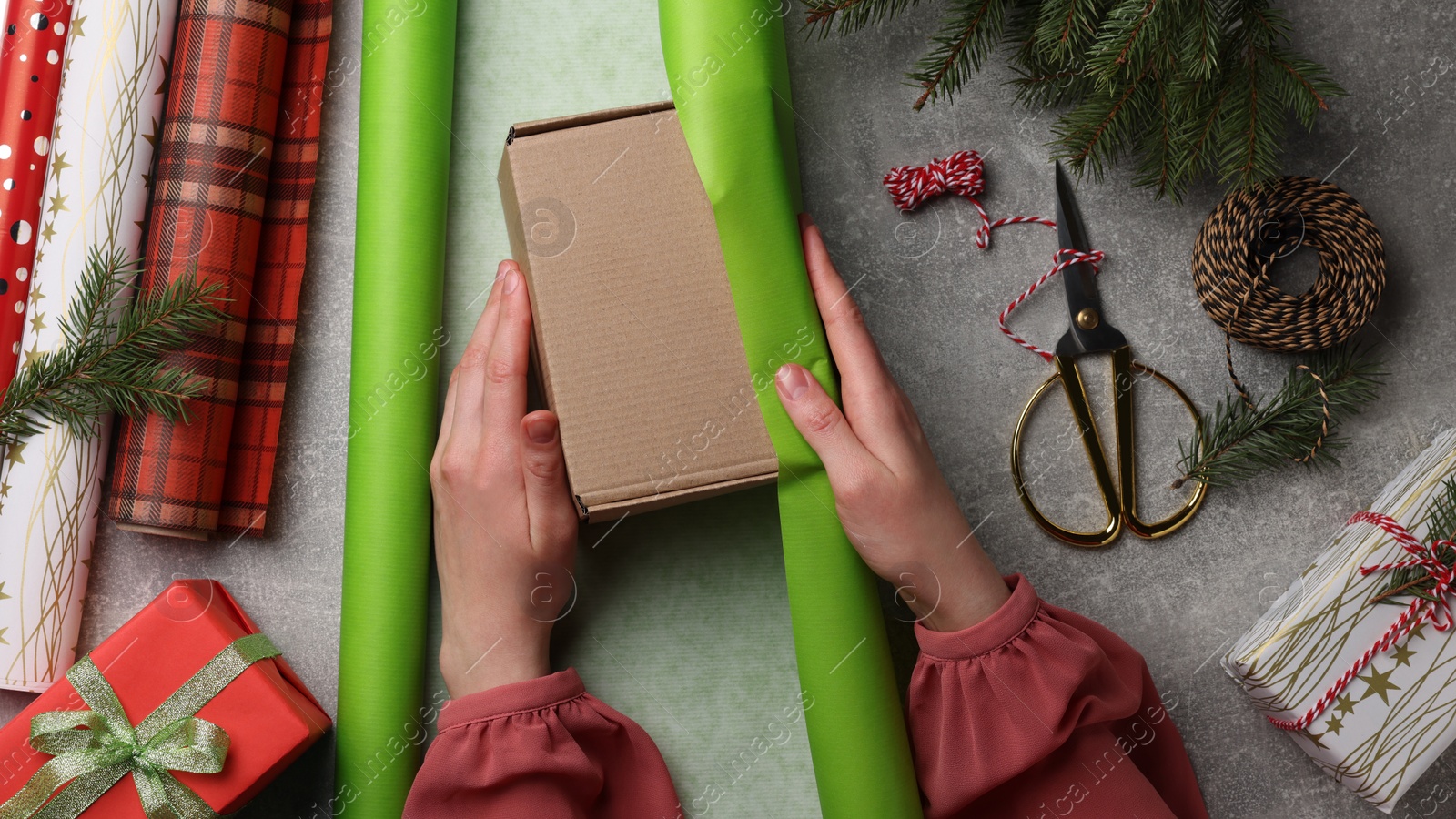 Photo of Woman Christmas gift at grey stone table, top view