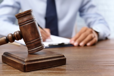 Photo of Wooden gavel and blurred lawyer on background. Notary services