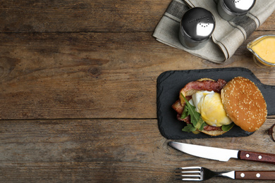 Delicious egg Benedict served on wooden table, flat lay. Space for text