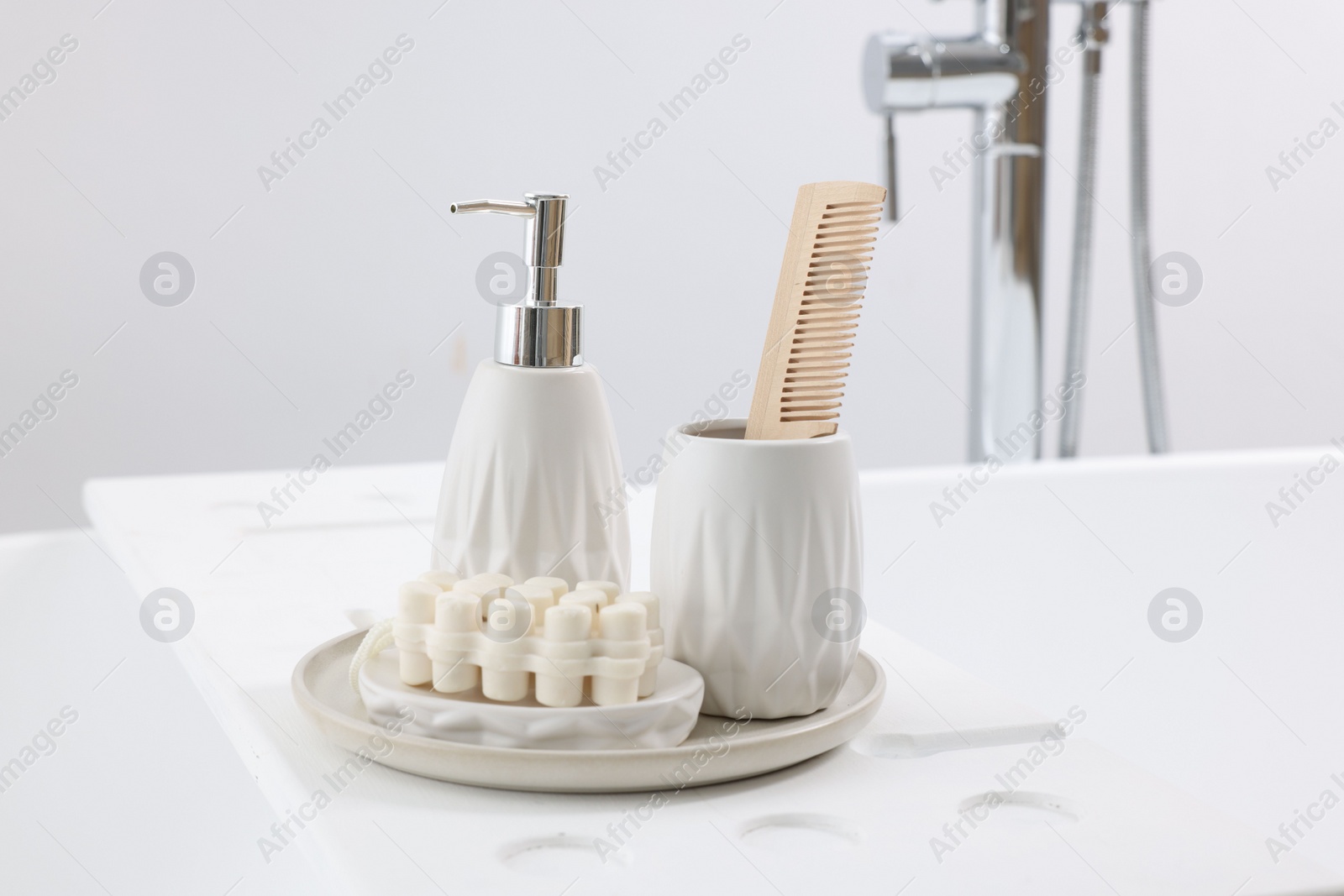 Photo of Different personal care products and accessories on bath tub in bathroom