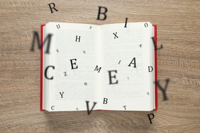 Image of Open book with letters flying out of it on wooden background, top view