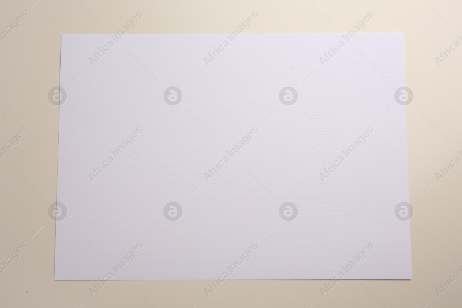 Photo of Sheet of parchment paper on beige background, top view