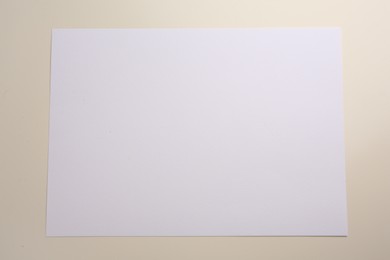 Sheet of parchment paper on beige background, top view