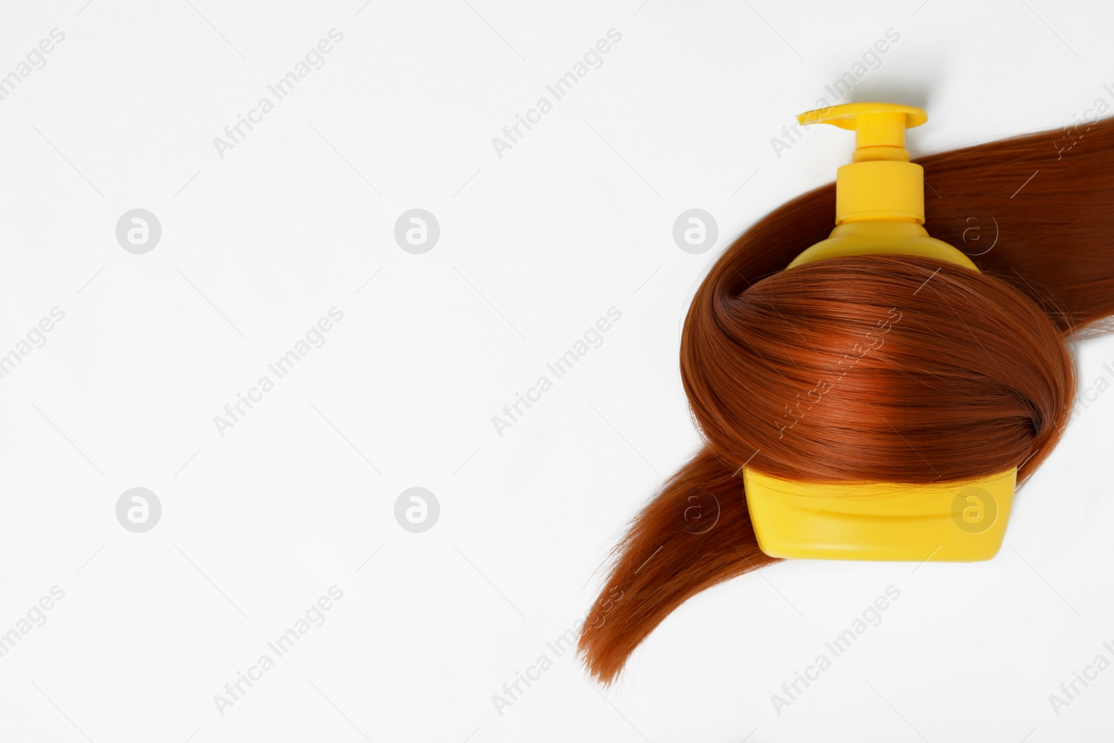 Photo of Shampoo bottle wrapped in lock of hair isolated on white, top view. Natural cosmetic products