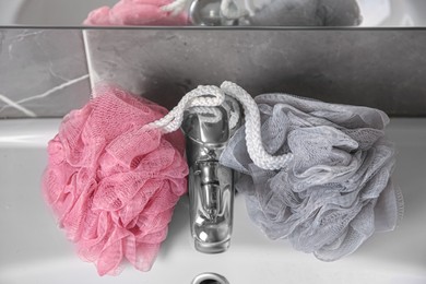 Colorful shower puffs between faucet on sink in bathroom, above view