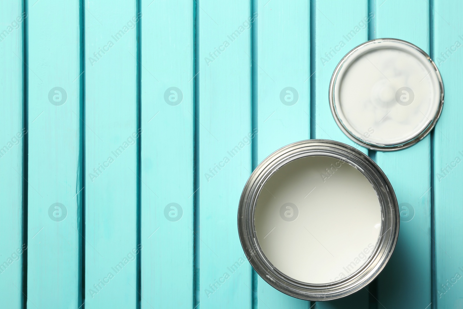 Photo of White paint can on blue wooden background, top view. Space for text