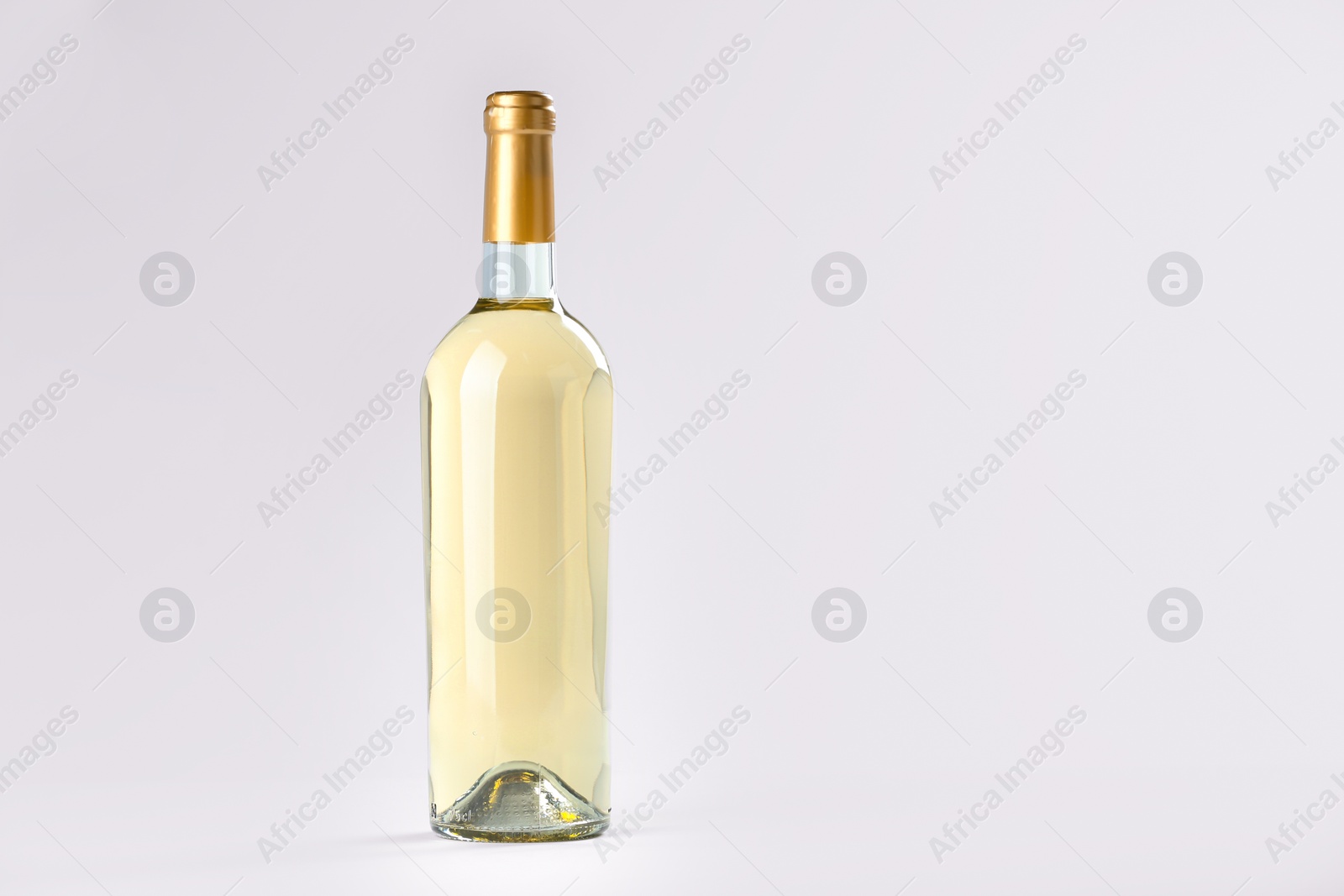 Photo of Bottle of expensive white wine on light background. Space for text