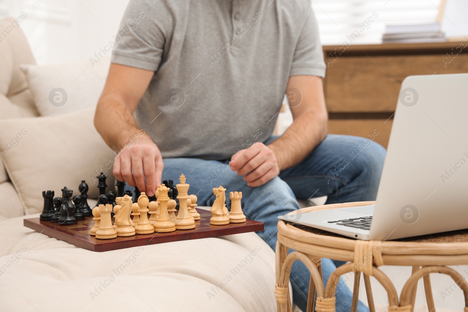 Photo of Man playing chess with partner through online video chat at home, closeup