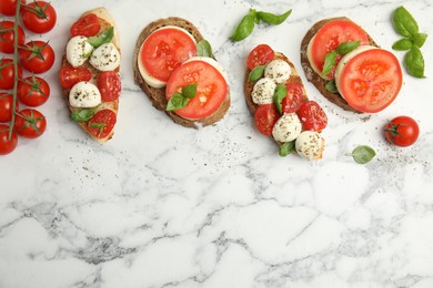 Photo of Delicious sandwiches with mozzarella, fresh tomatoes and basil on white marble table, flat lay. Space for text