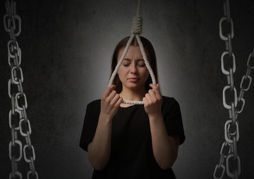 Image of Depressed woman with rope noose on dark background