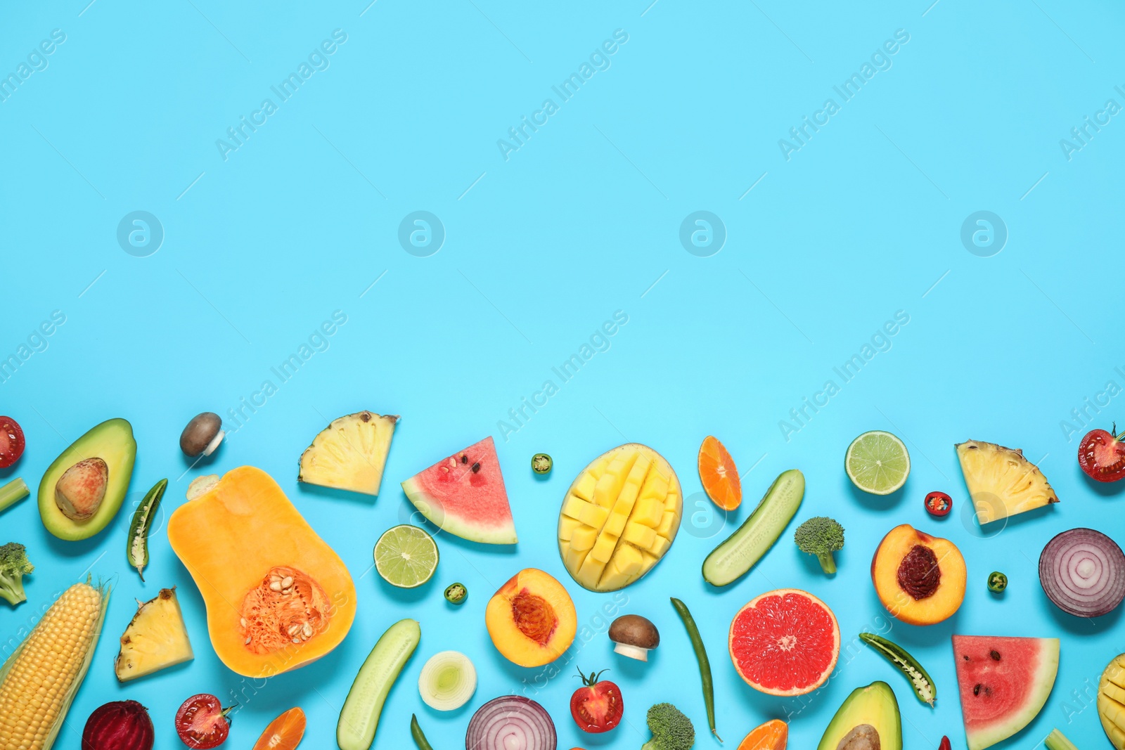 Photo of Flat lay composition with fresh organic fruits and vegetables on light blue background. Space for text