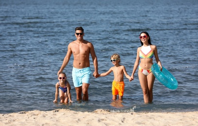 Happy family with inflatable ring in sea. Summer holidays