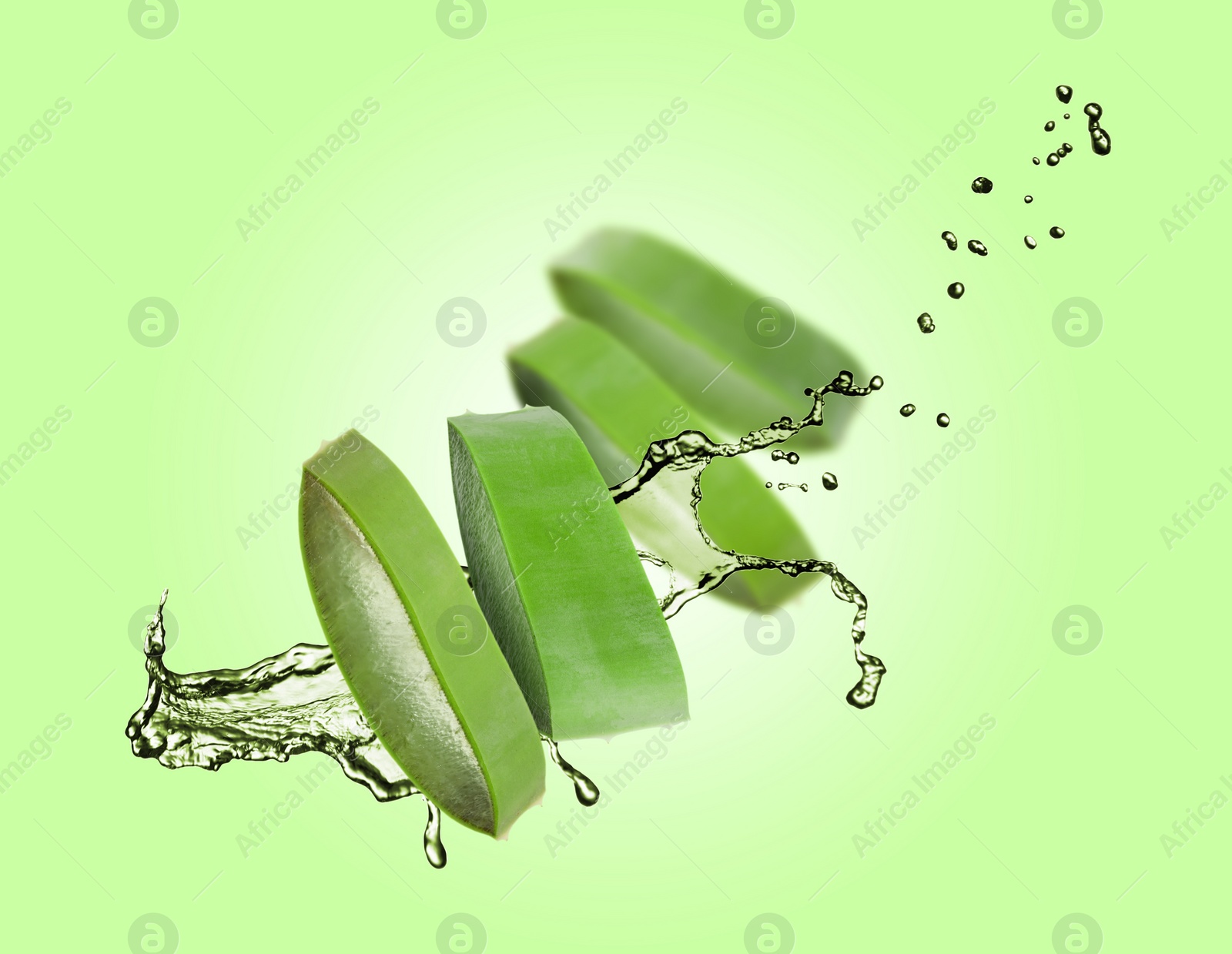 Image of Sliced aloe vera leaf and splashes of juice on green background