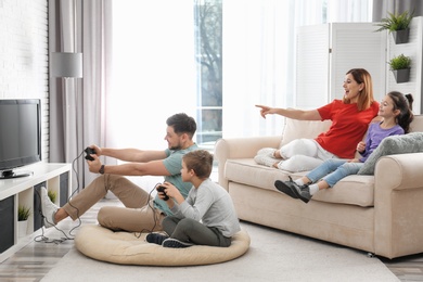 Happy family playing video games in living room