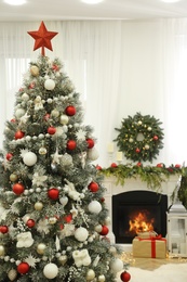 Beautiful Christmas tree with star topper in decorated room