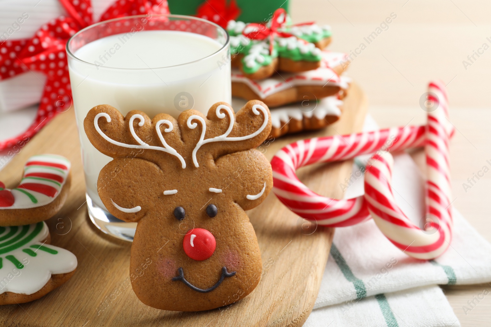 Photo of Decorated Christmas cookies and glass of milk on wooden table, closeup