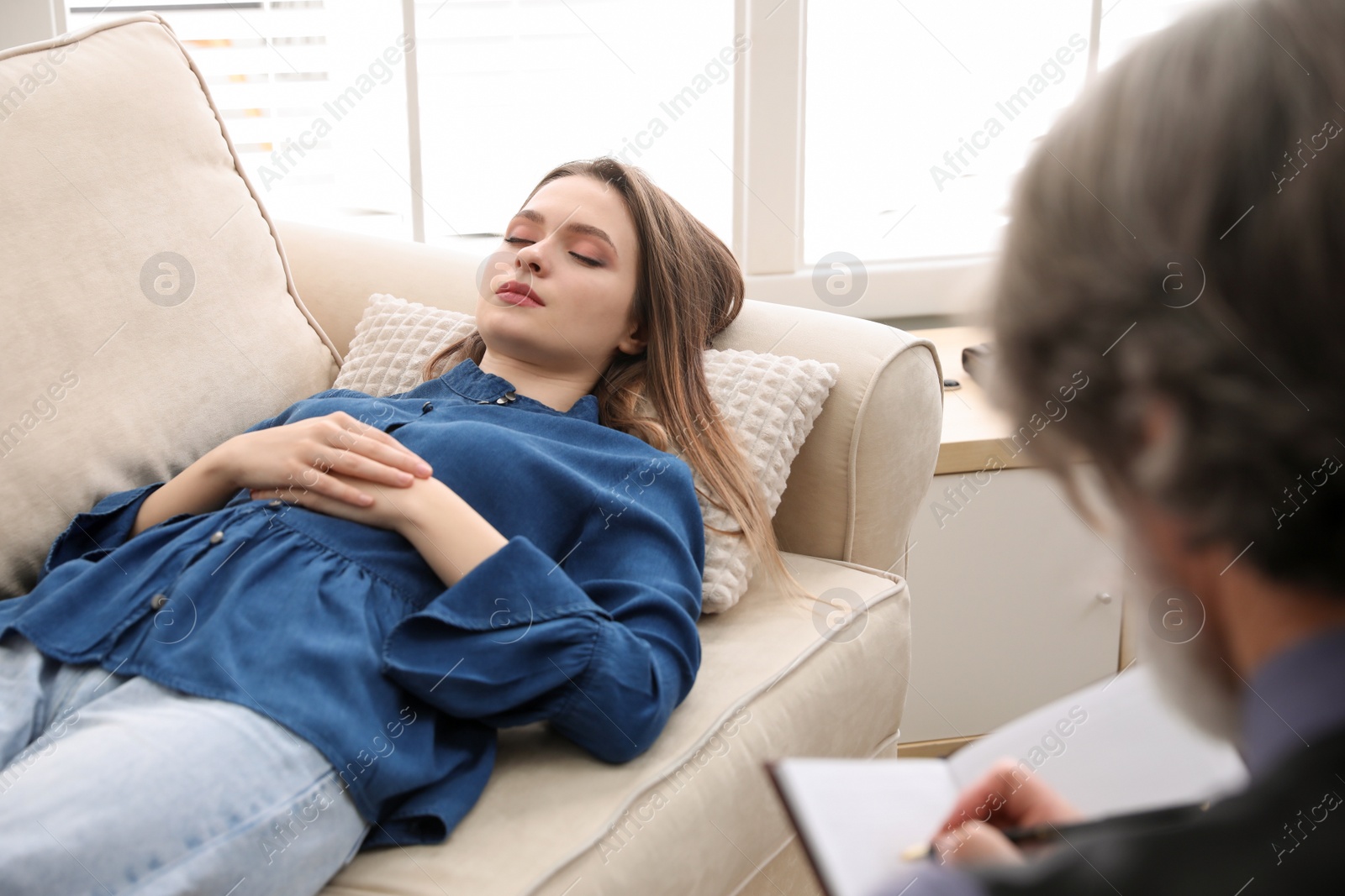 Photo of Psychotherapist and patient in office. Hypnotherapy session