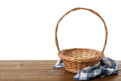 Wicker basket and towel on wooden table against white background, space for text. Easter item