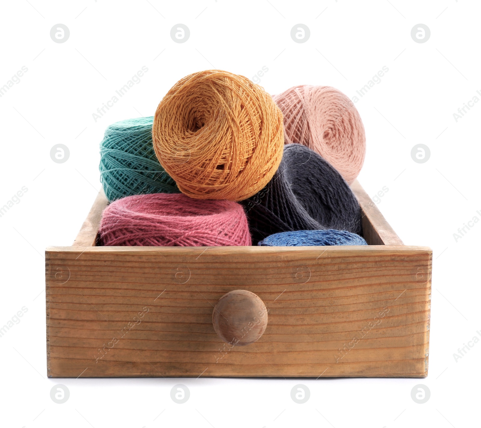 Photo of Wooden drawer with clews of colorful knitting threads on white background