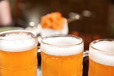 Glasses of tasty beer on blurred background, closeup