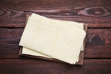 Photo of Delicious Armenian lavash on wooden table, top view