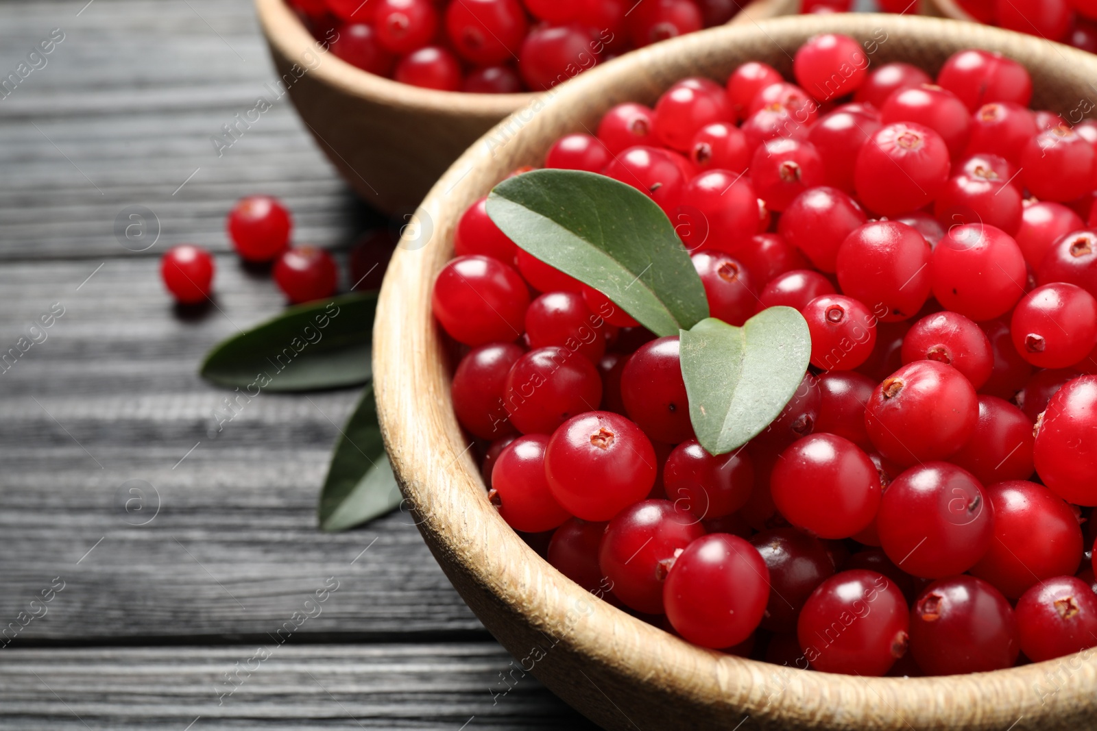 Photo of Ripe fresh cranberry on grey wooden table, closeup