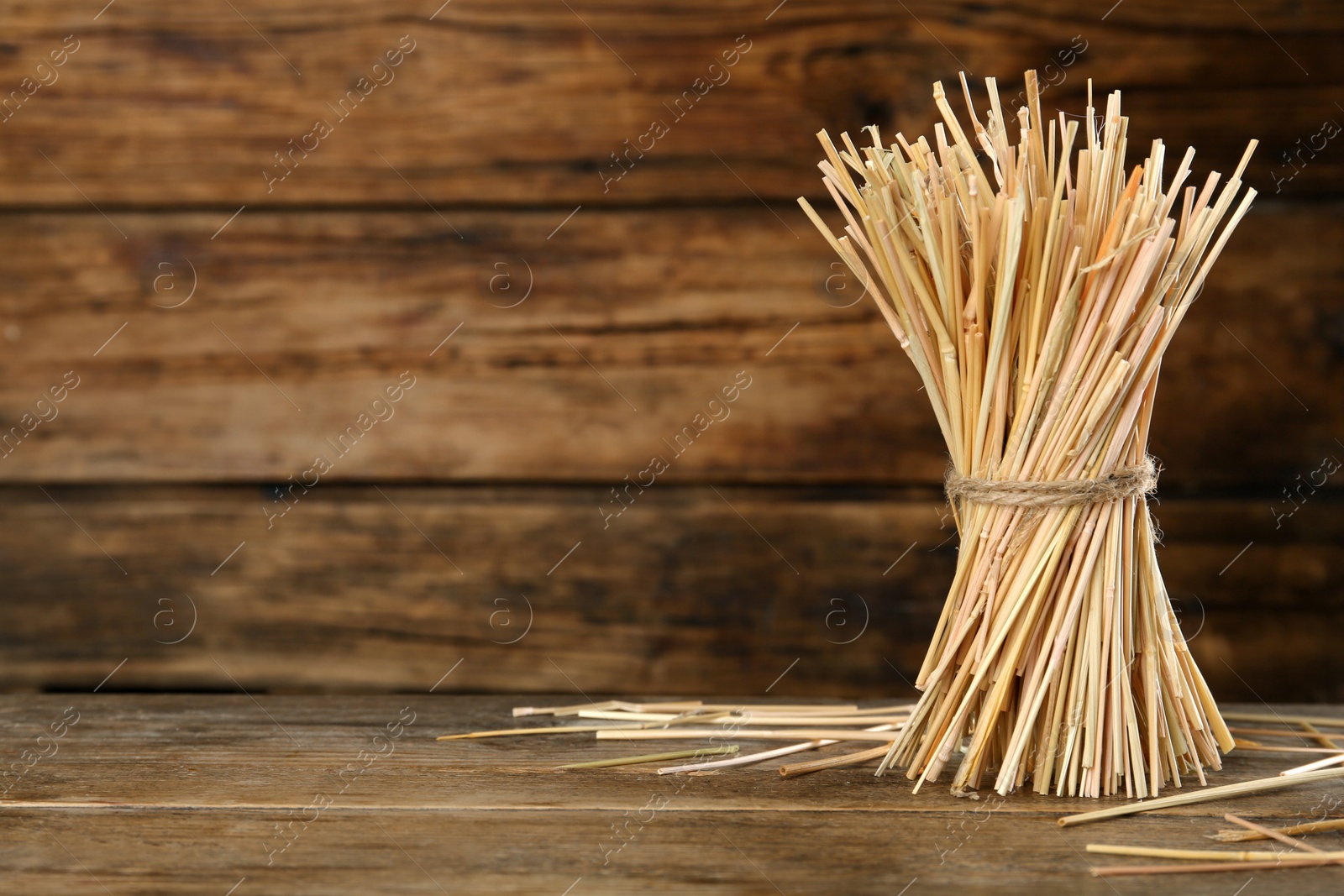 Photo of Sheaf of hay on wooden table. Space for text