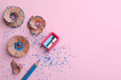 Photo of Pencil, shavings and sharpener on pink background, flat lay. Space for text