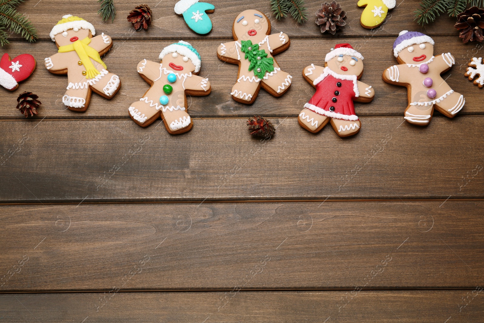 Photo of Delicious Christmas cookies and pine cones on wooden table, flat lay. Space for text