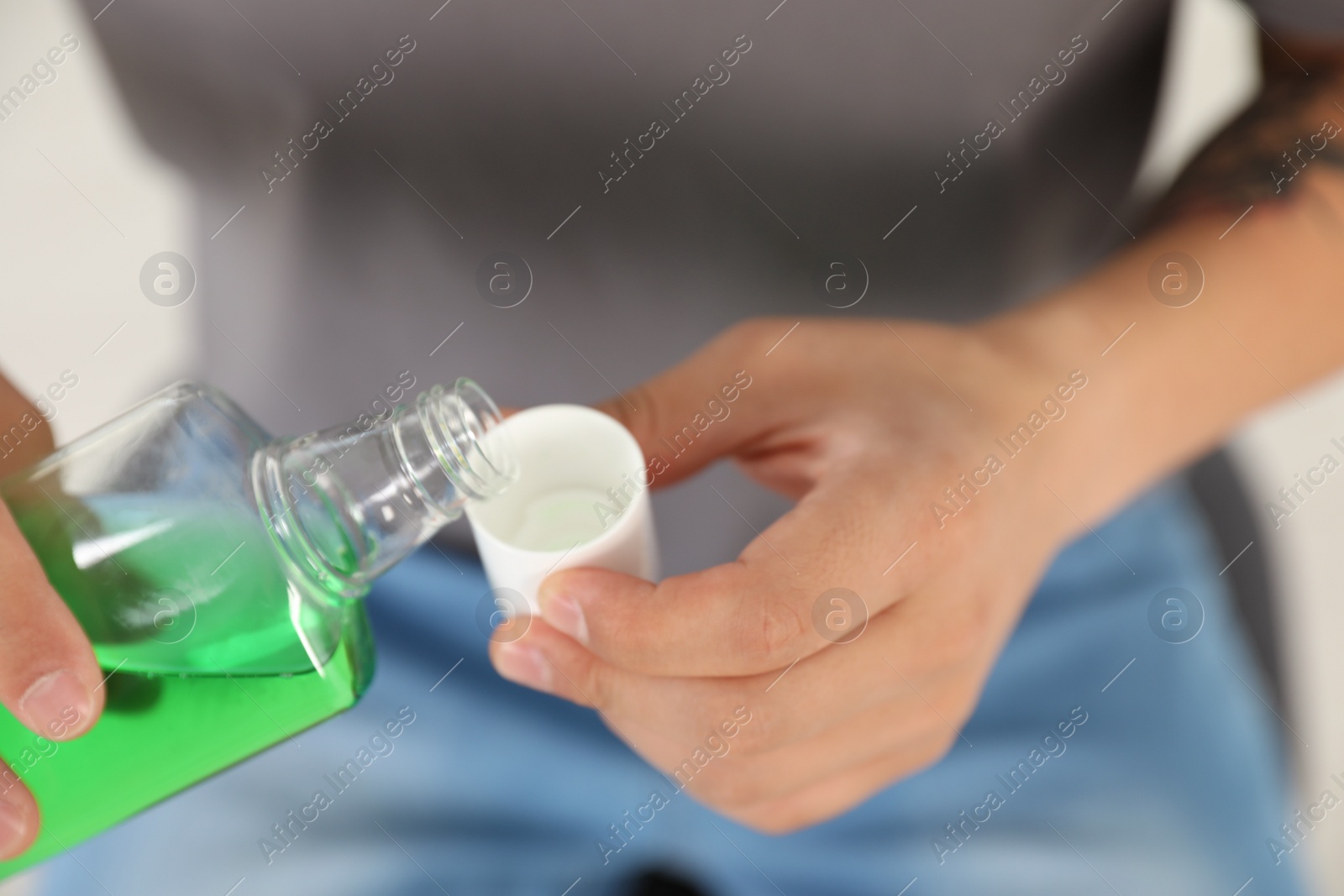 Photo of Man pouring mouthwash from bottle into cap, closeup. Teeth care