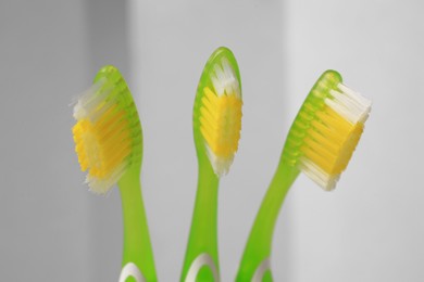 New toothbrushes on blurred background, closeup view