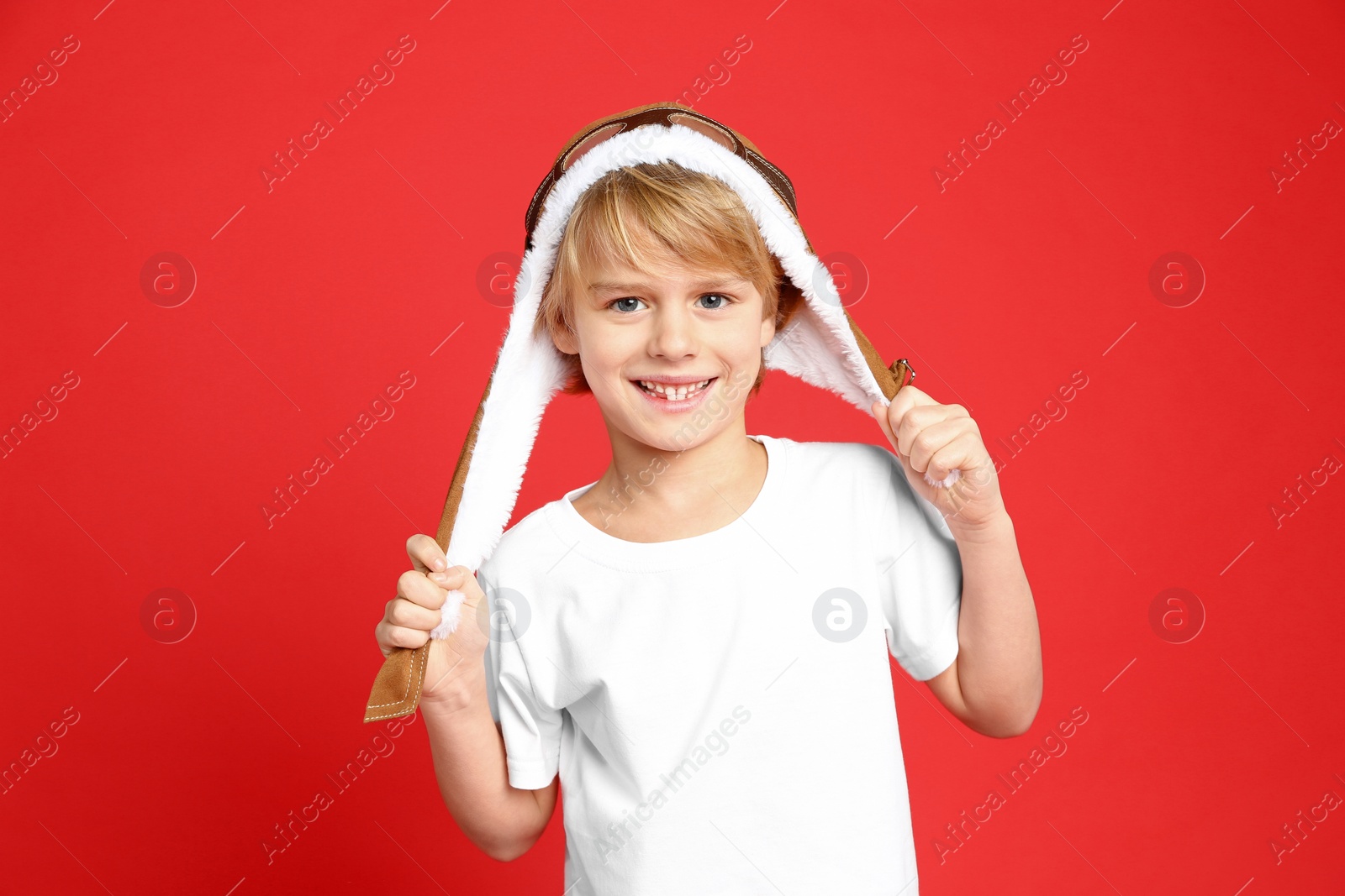 Photo of Cute little boy wearing hat on red background