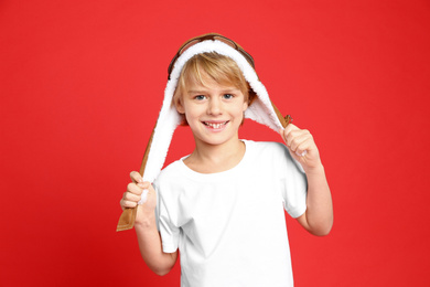 Photo of Cute little boy wearing hat on red background
