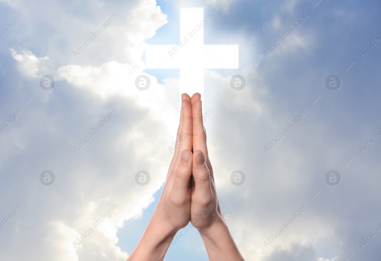 Image of Religion. Christian man praying against sky with glowing cross, closeup