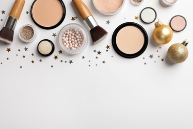 Flat lay composition with makeup products and Christmas decor on white background. Space for text