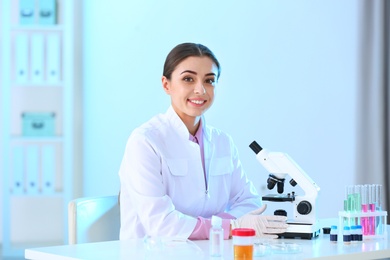 Photo of Young scientist with microscope in laboratory. Chemical analysis