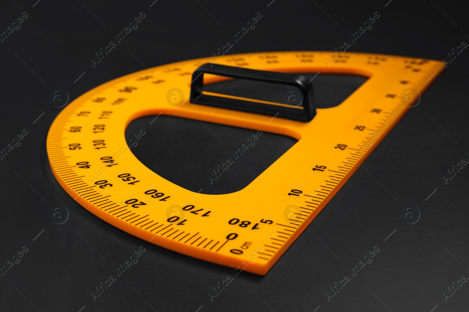 Photo of Yellow school protractor on blackboard, closeup view