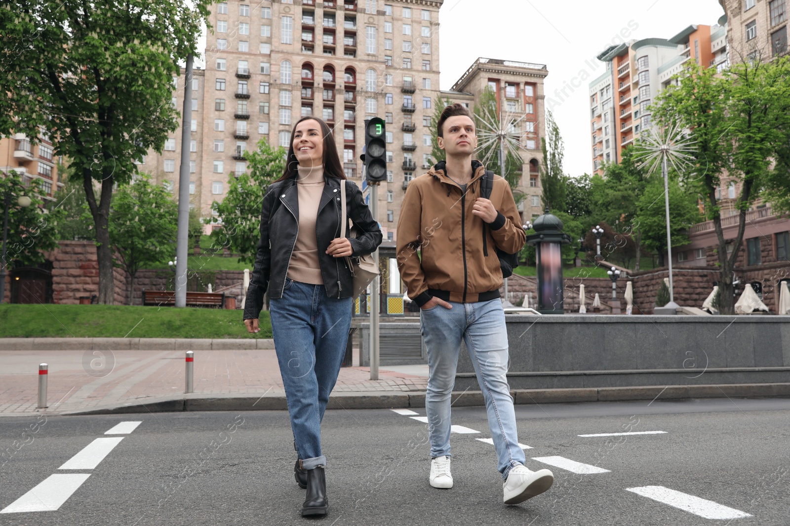 Photo of Young people crossing street at traffic lights