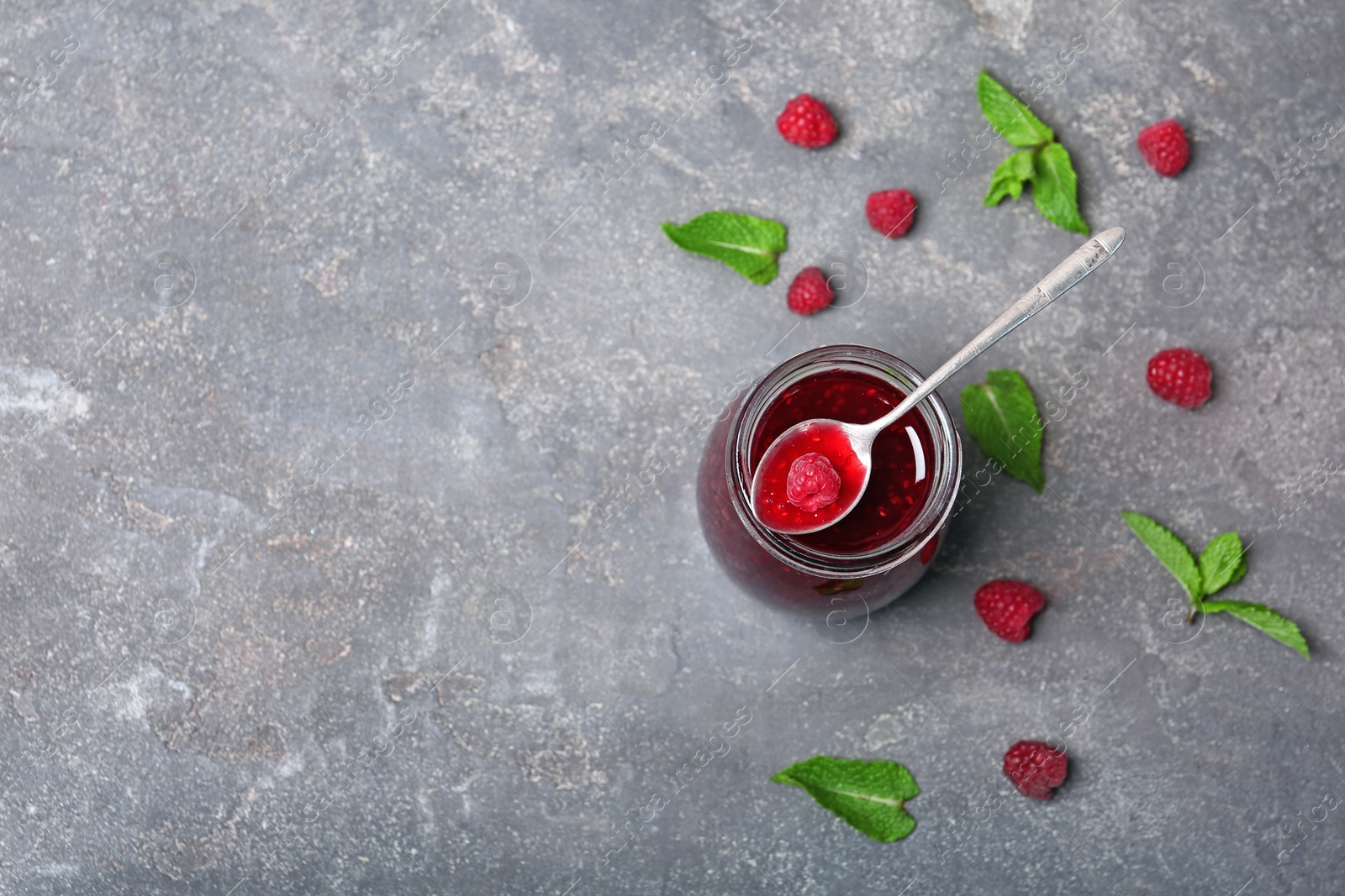 Photo of Flat lay composition with delicious raspberry jam on grey background