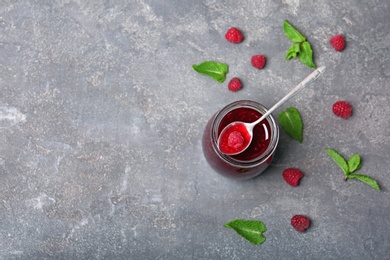 Photo of Flat lay composition with delicious raspberry jam on grey background