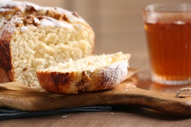 Delicious yeast dough cake and tea on wooden table, closeup